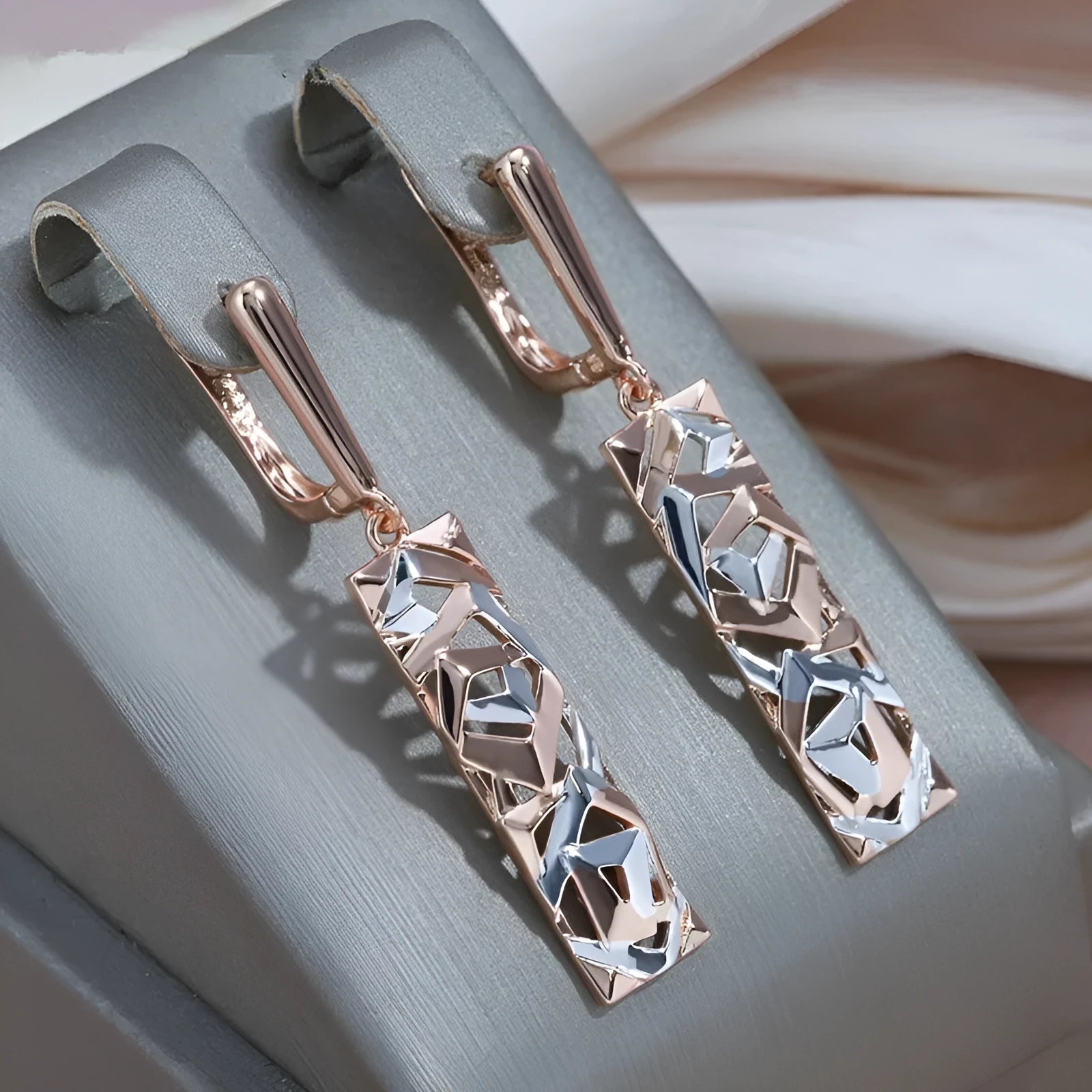 A pair of women's rectangular hollow stud earrings with a two-tone metal finish.