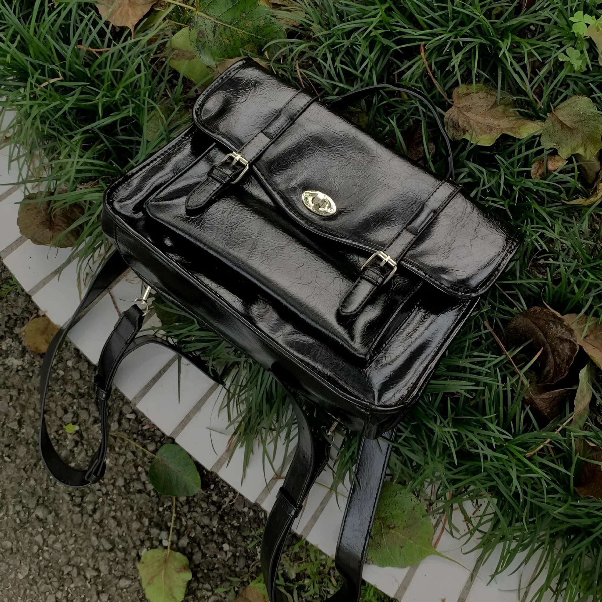 Black college messenger bag with oil wax leather finish showing crossbody strap and satchel design