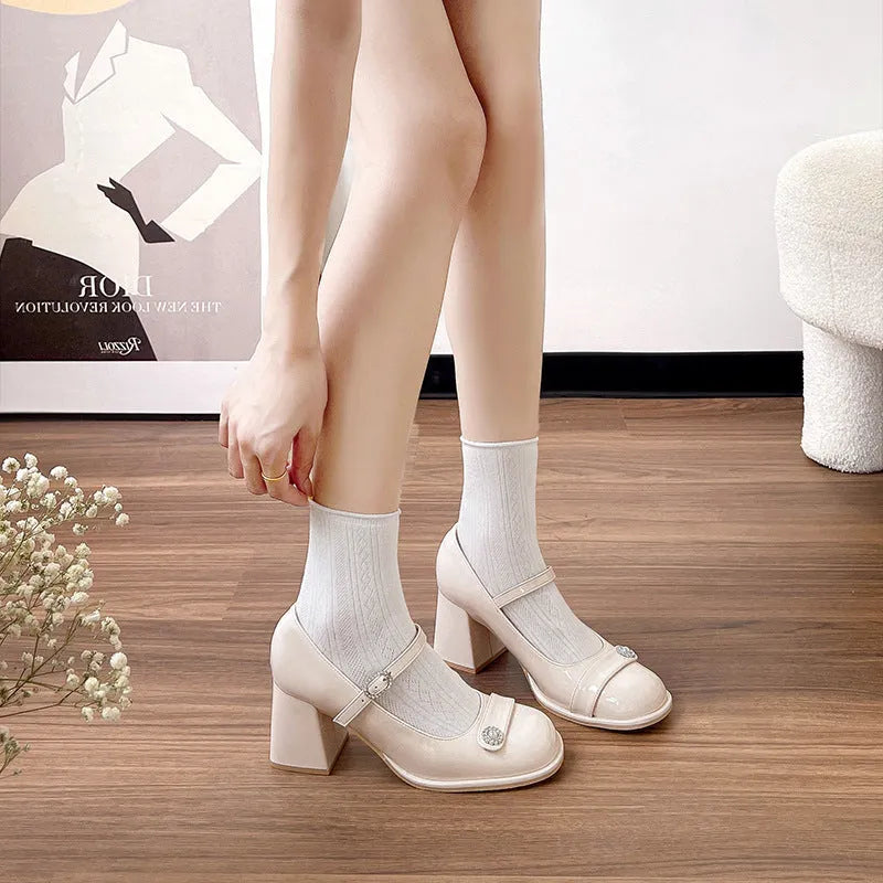 Black patent leather women's chunky heel shoes with round toe and buckle fastening.