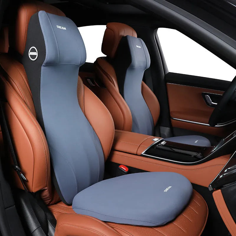 Black automotive memory foam cushion and headrest lumbar support pillow set on a car seat.