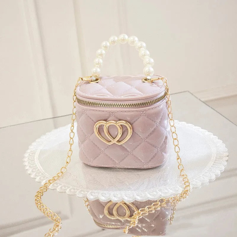 White PVC bucket-shaped cosmetic bag with a red heart pattern, zipper open.