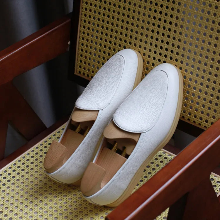 Men's brown genuine leather handmade loafers on a white background.