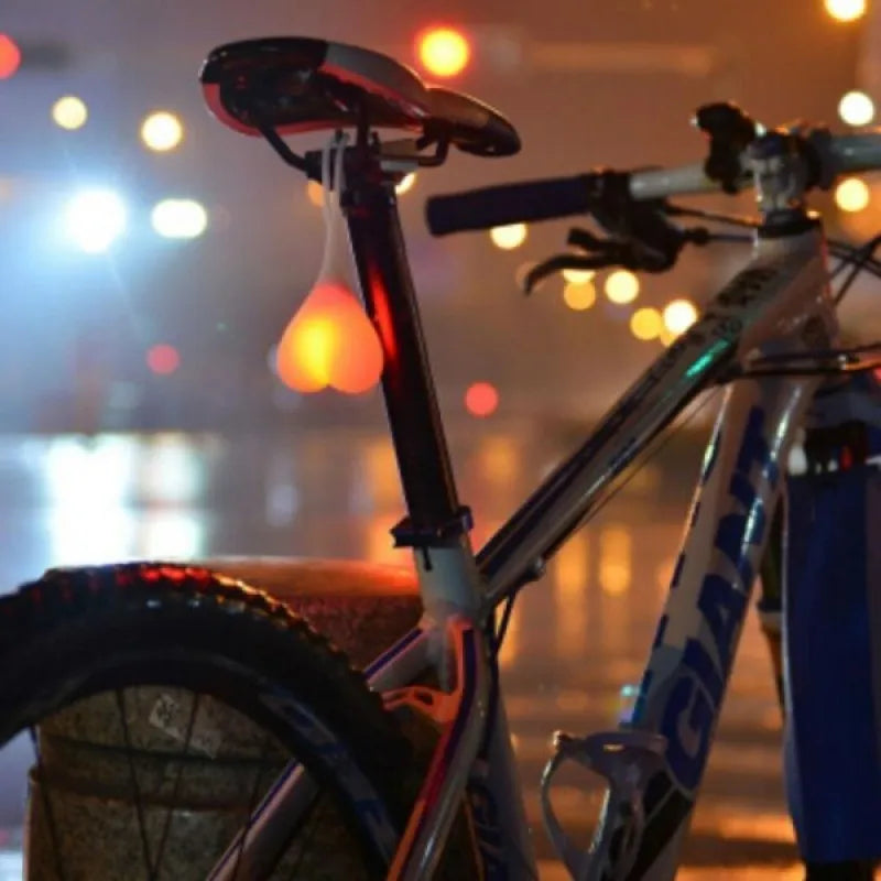 Heart-shaped silicone bike rear light, 15 cm long, touch activated, waterproof, in red blue green.