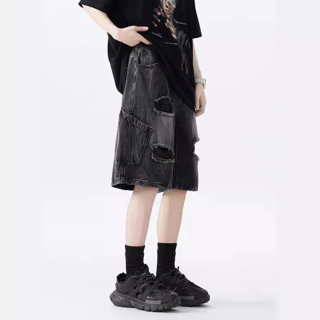 Loose-fit denim shorts with a washed fabric finish and ripped, distressed detailing on the legs.