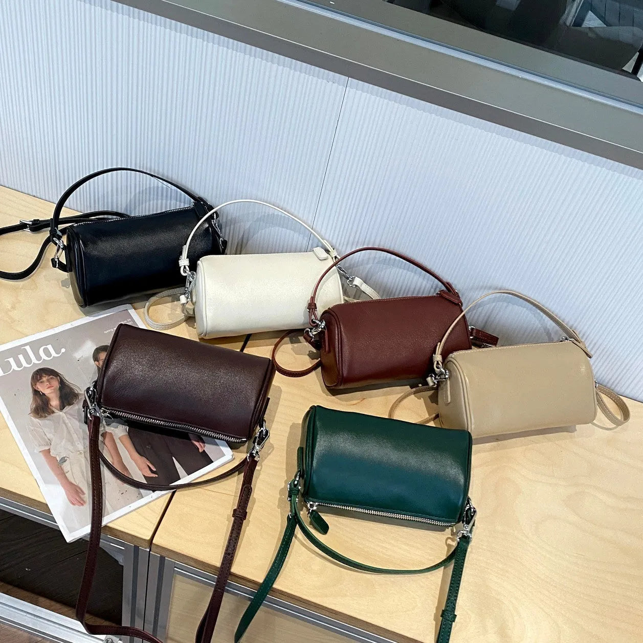 Genuine leather cylindrical crossbody bag for mobile phones in a street style, shown in brown.