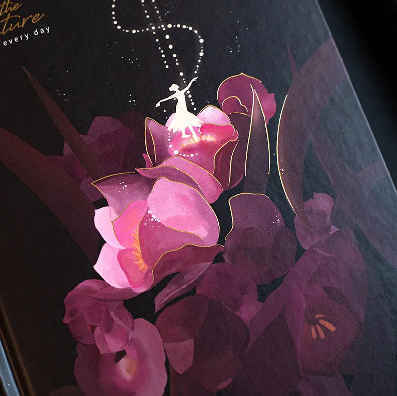 A5 notebook with luminous cover in blue, gold, light blue, or purple, open to show pages for colour illustration.