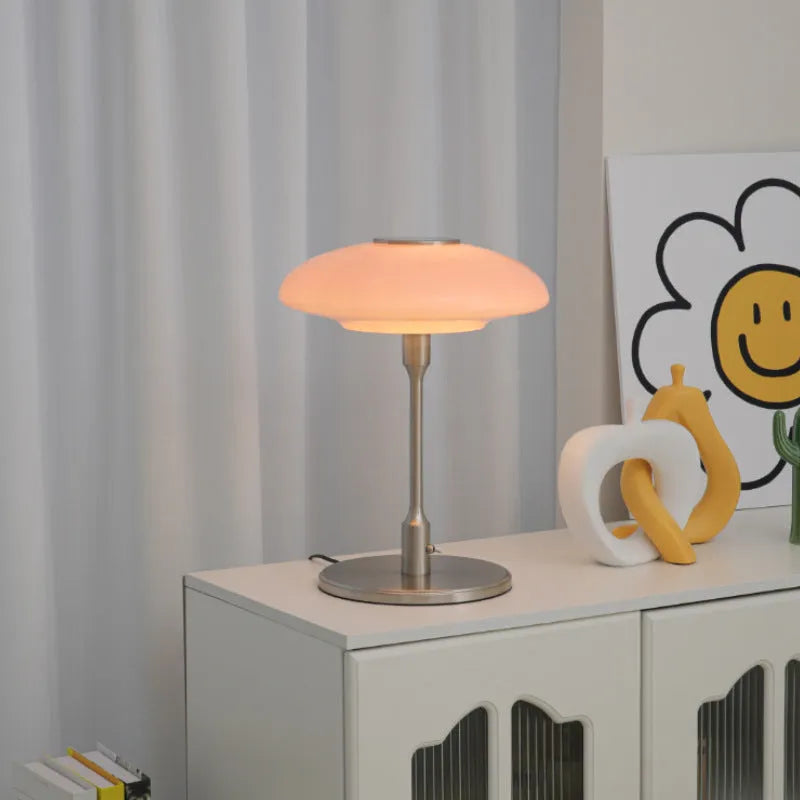Korean style golden orange atmosphere light with metal base on a bedside table.