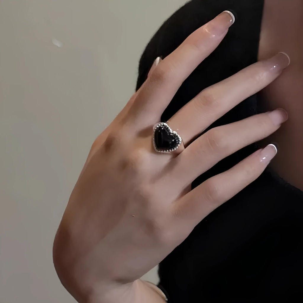 Adjustable opening sterling silver ring with black agate heart stone design on finger