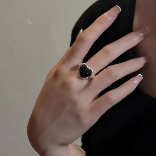 Adjustable opening sterling silver ring with black agate heart stone design on finger