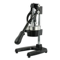 Tall black cast iron manual citrus juicer with stainless steel funnel on a kitchen counter.