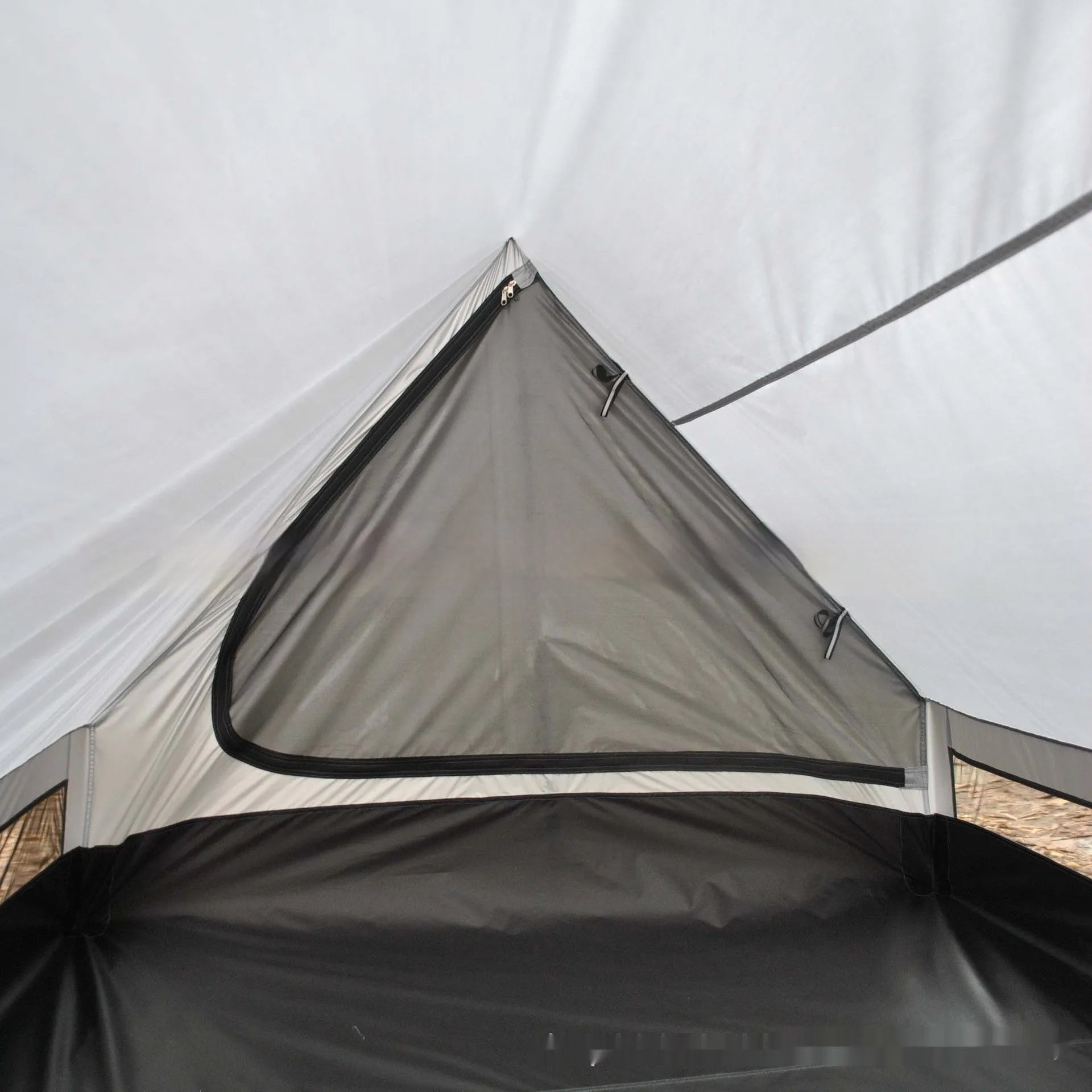 Brown and white pole-free A-line cabin tent set up with hiking canes, showing spacious interior