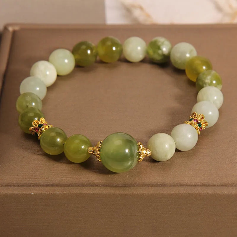Xiuyan jade green women's bracelet with original design on a wrist.