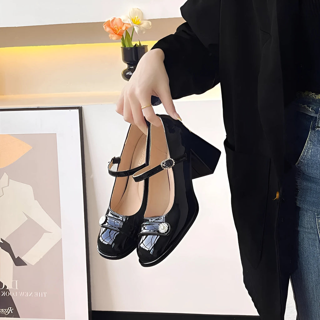 Black patent leather women's chunky heel shoes with round toe and buckle fastening.