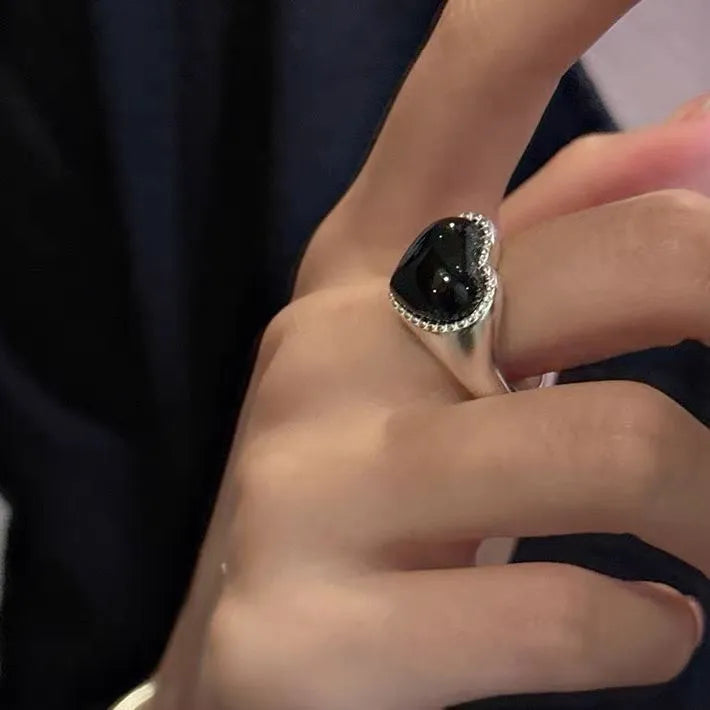 Adjustable opening sterling silver ring with black agate heart stone design on finger