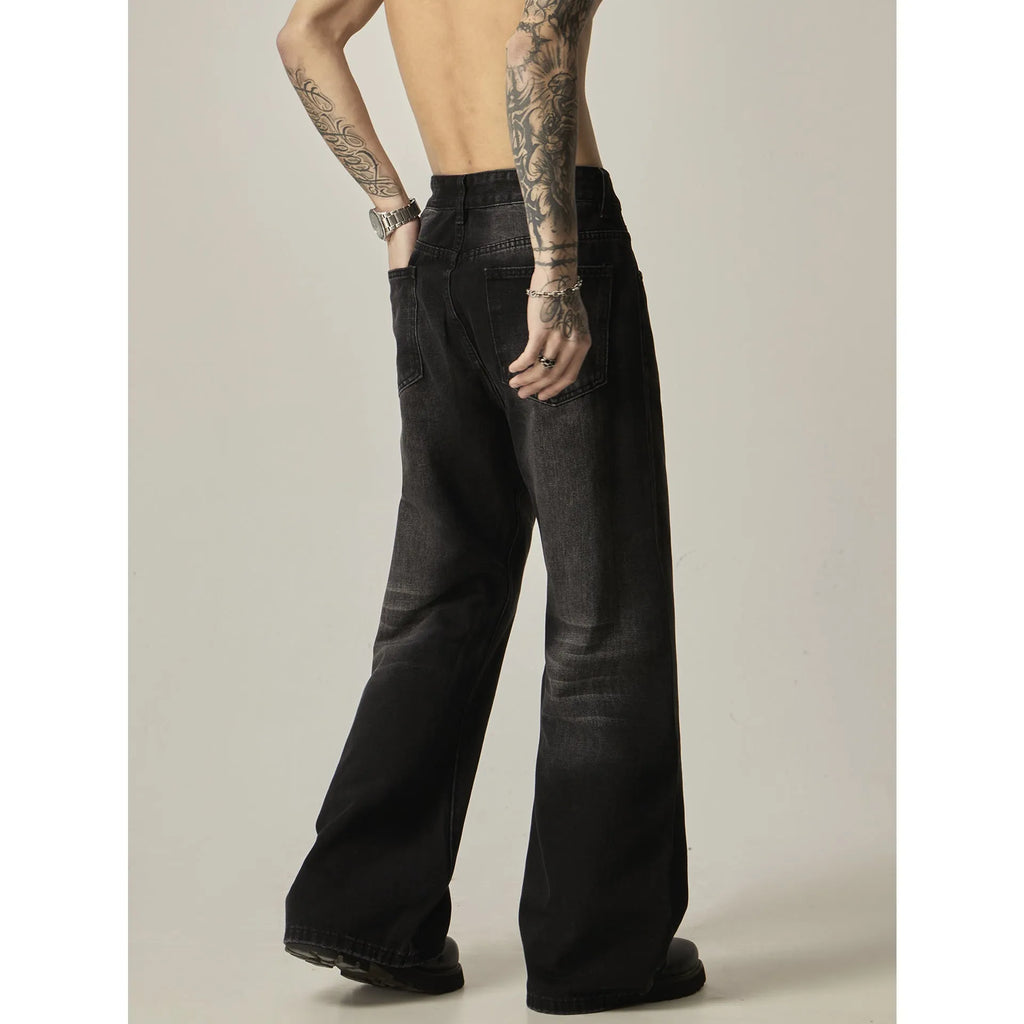 Black loose straight leg retro jeans on a hanger, showing zipper fly detail.
