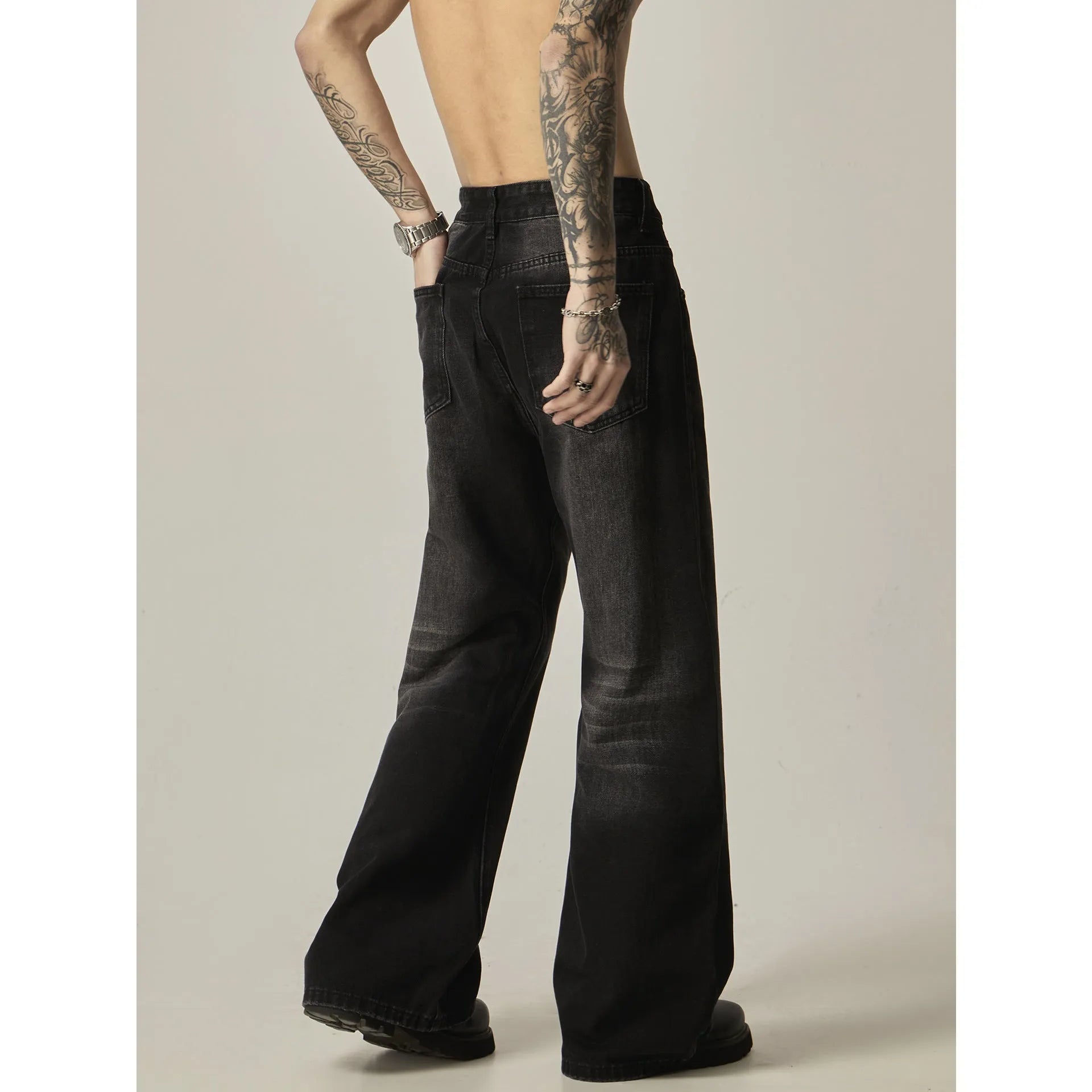 Black loose straight leg retro jeans on a hanger, showing zipper fly detail.