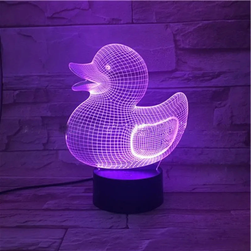 Little yellow duck 3D night light on a table showing its cartoon design and colourful illumination.