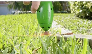 Cordless Zip Trim lawn trimmer with extension pole and protective shield on garden grass