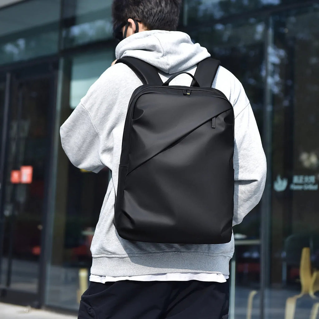 Waterproof PU leather laptop backpack in black, blue, and grey colour options