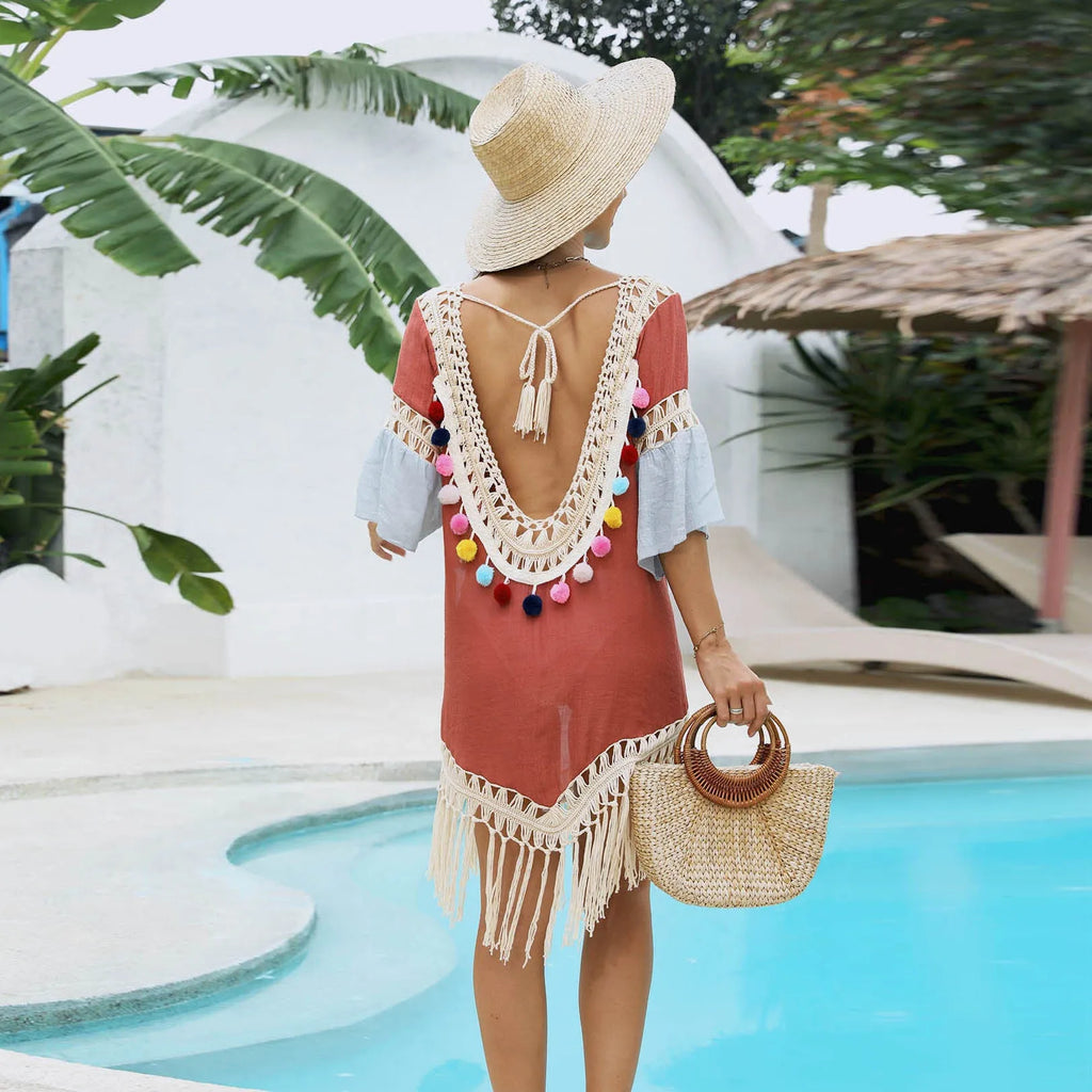 Orange floral beach overskirt with hand crochet detail and tassels, laid flat.