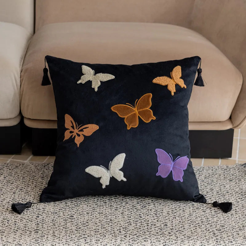 Square beige couch pillow with detailed Chinese-style butterfly embroidery.