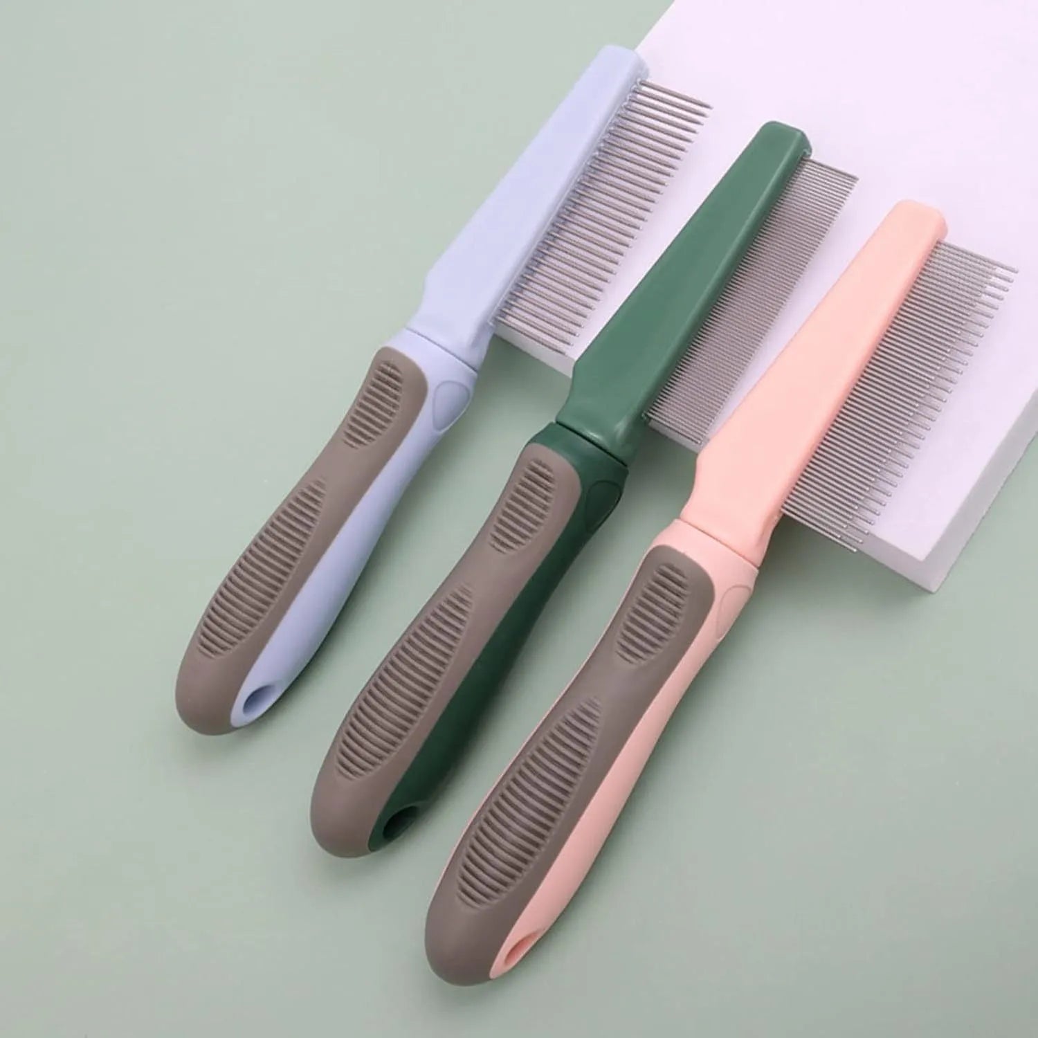 Blue pet detangler comb showing three different tooth patterns and rubber handle