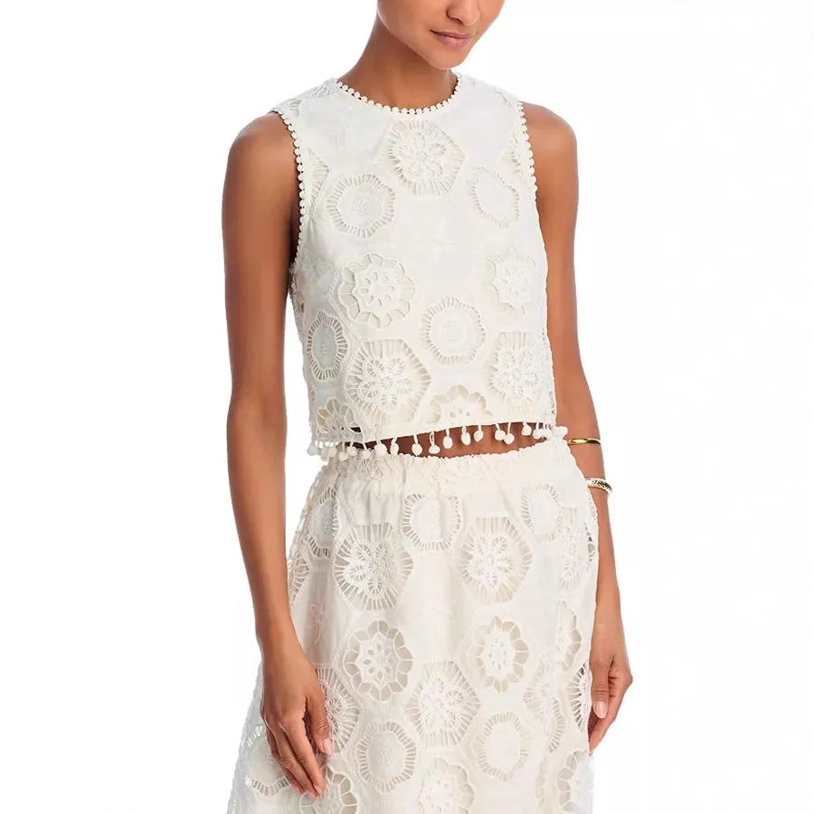 White women's sleeveless top and long skirt suit with embroidery detail on a mannequin.
