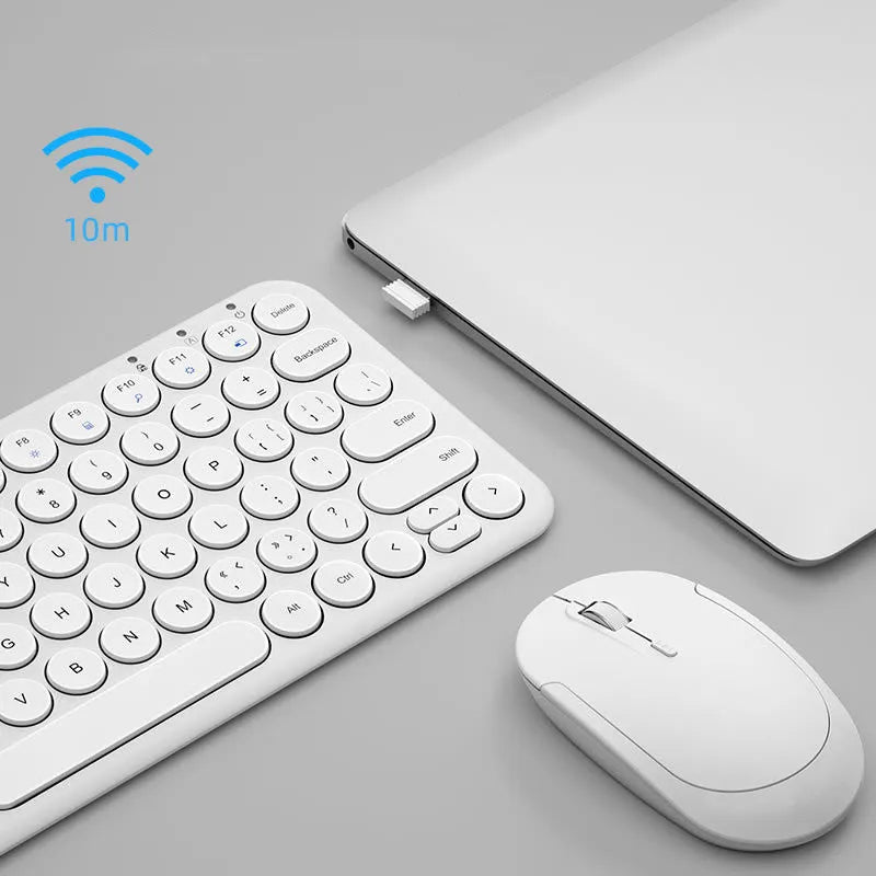 A slim white wireless keyboard and mouse set with a USB receiver on a desk.