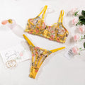Floral mesh bra and matching T-back briefs set with a steel ring detail, shown in skin colour.