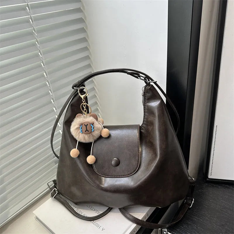 Women's black PU leather single shoulder bag with horizontal square shape and optional pendant attachment