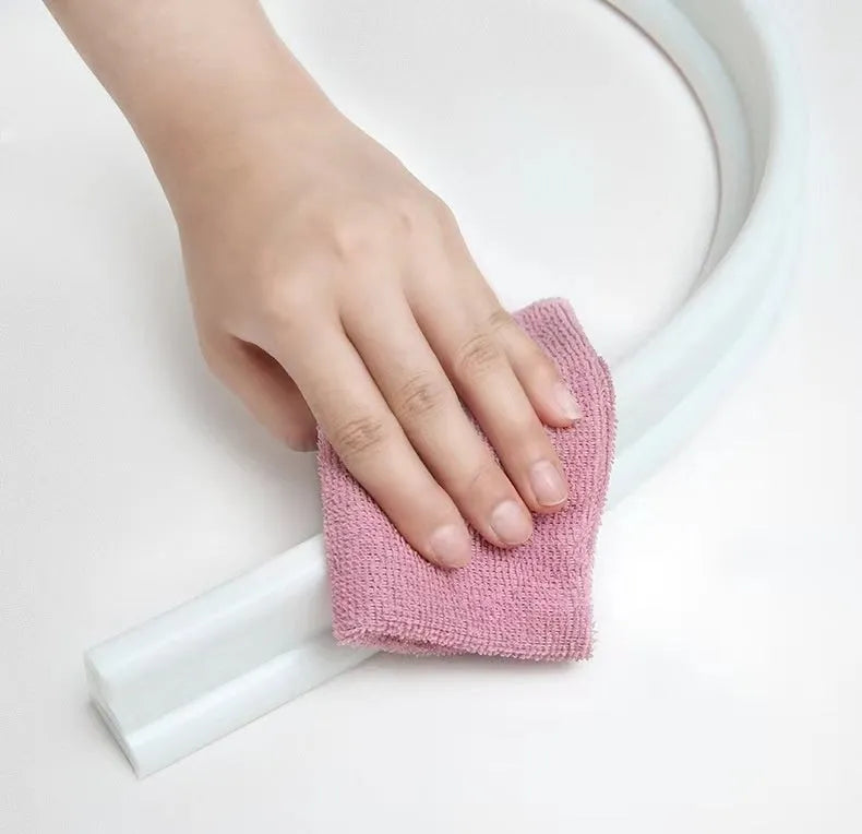 Flexible TPE bathroom water blocking strip in black on white tile floor