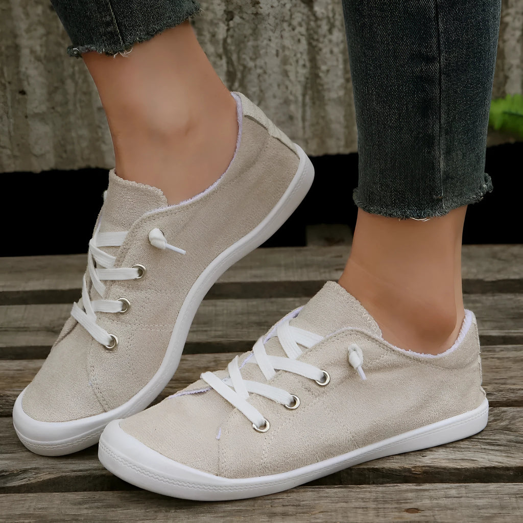 Creamy-white women's low-top fabric casual sneakers with a rubber sole.
