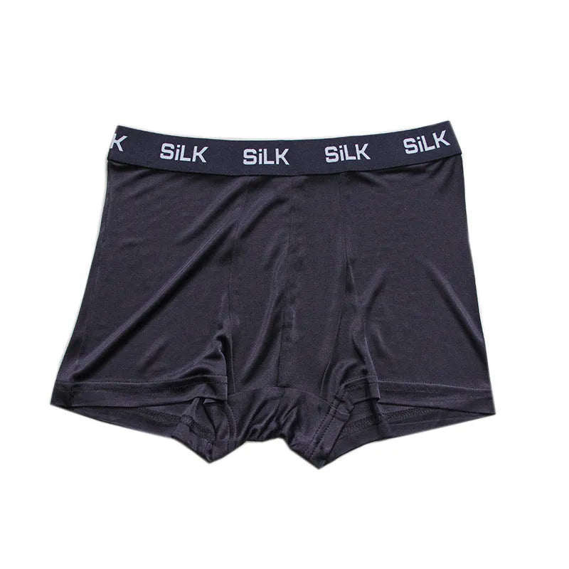 Men's loose fit silk shorts in navy blue on a neutral background