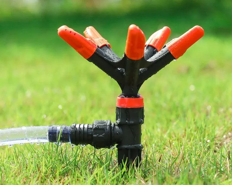 Orange plastic garden insert sprinkler with rotating water spray, 14 x 26.5cm, single nozzle