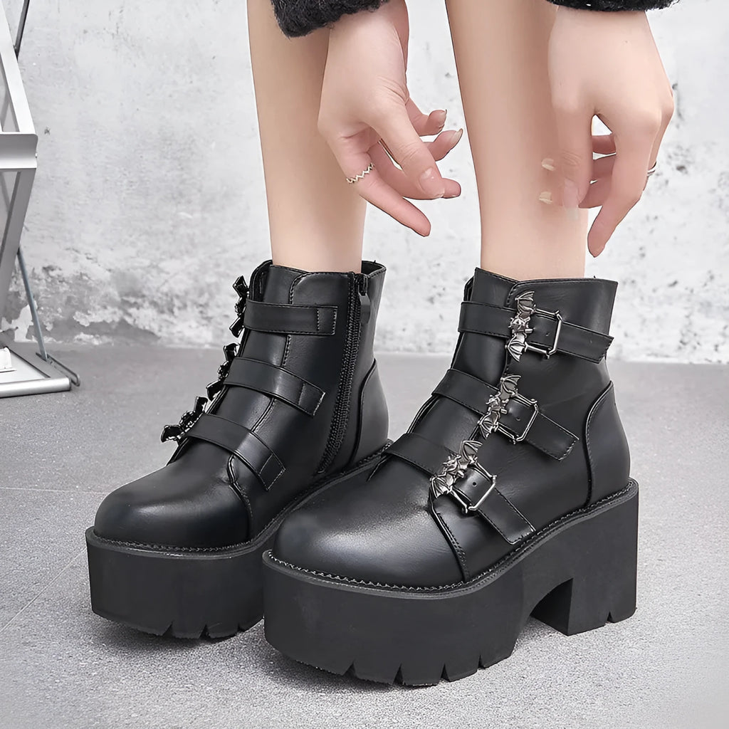 Black women's gothic punk Martin boots with bat buckle and side zipper on a thick heel.