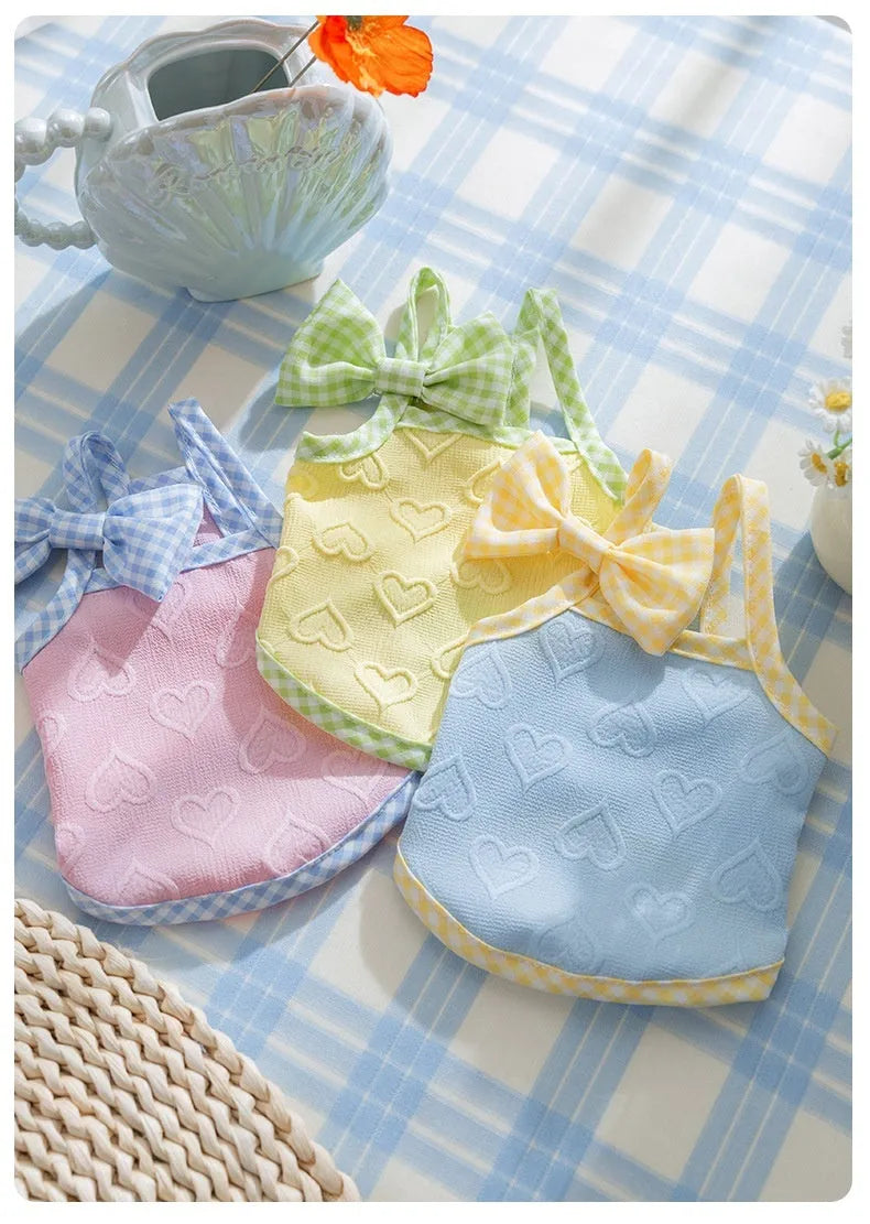 Small dog wearing heart relief texture bow suspenders vest in blue with matching hairband
