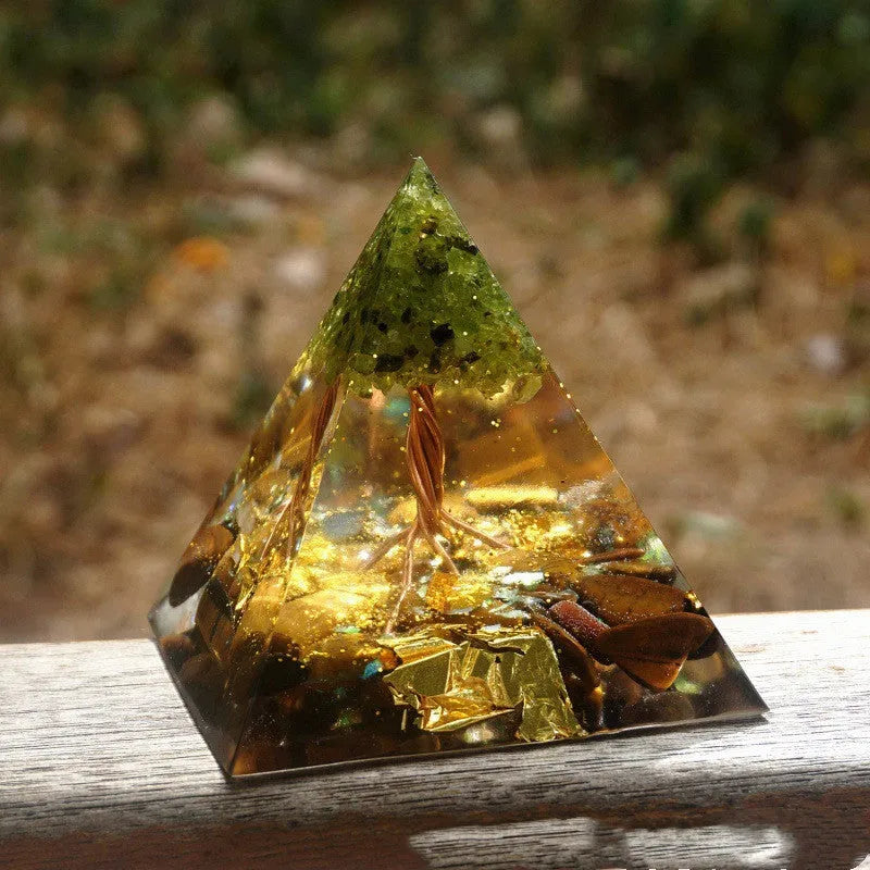 A small 6cm clear resin pyramid decoration with natural crystal gravel inside, on a neutral background.