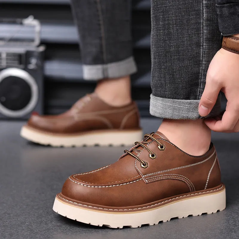 Men's black low-top Martin boots with round toe and rubber sole on wooden surface