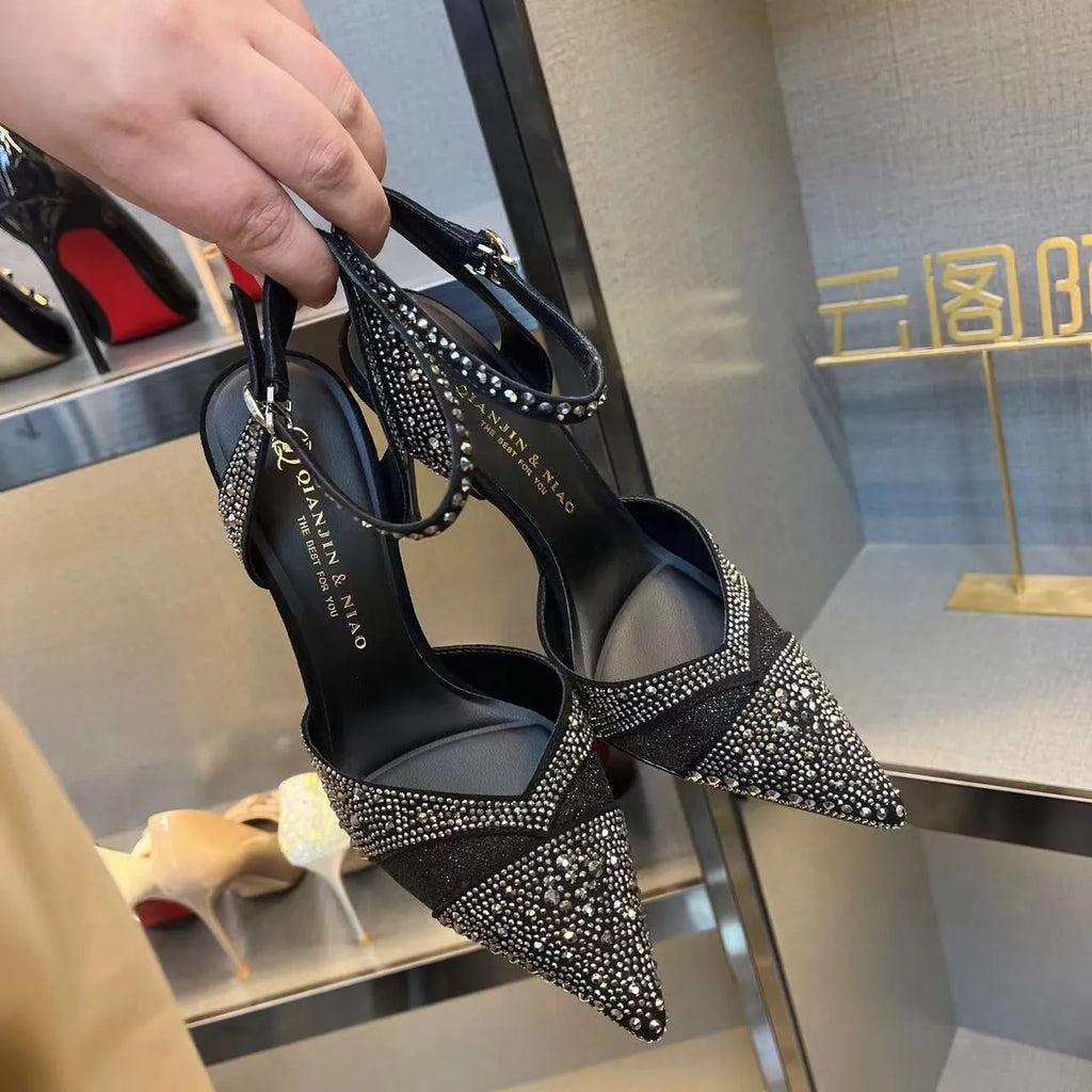 Women's black and silver hollow-cut stiletto high heels with pointed toes and red soles.