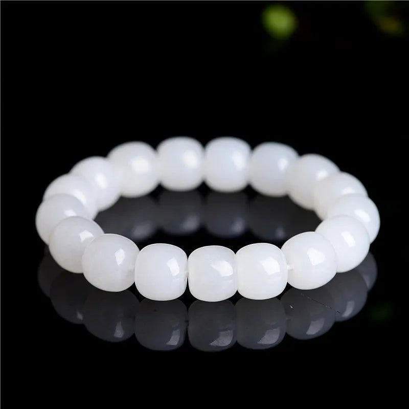 White Hetian jade barrel bead bracelet on a wrist, showing the traditional bead design.