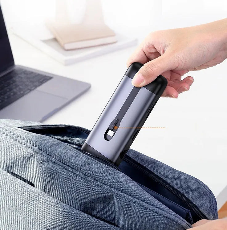 USB-C multi-port expansion dock showing HDMI, VGA, USB 3.0, Ethernet, and card reader ports with connected cables.