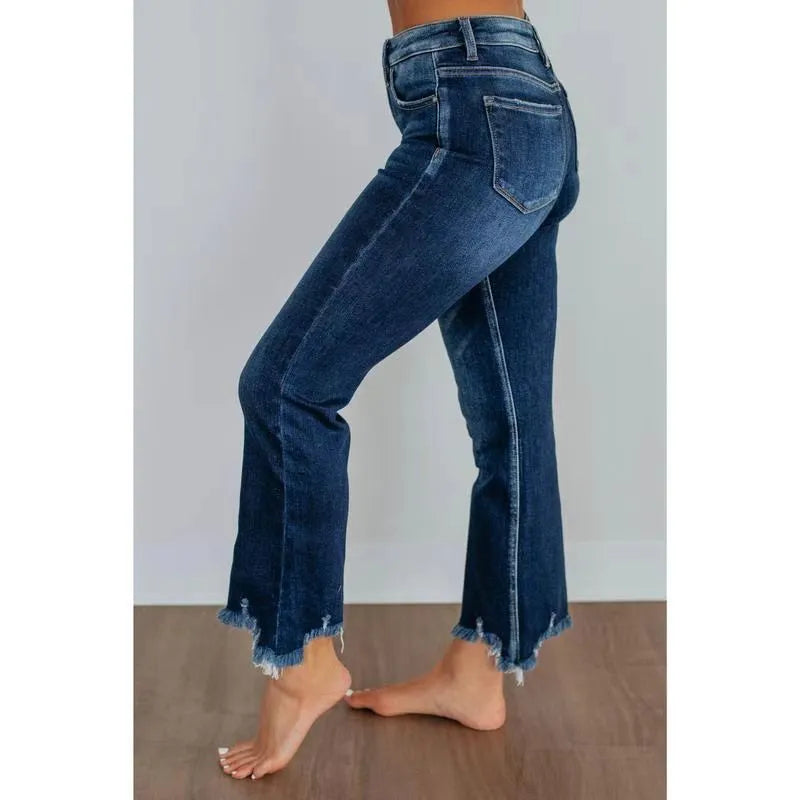 Solid colour women's denim trousers with hand-worn distressing on a hanger.