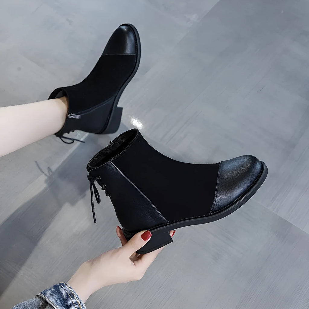 Women's black knee-high Martin boots with side zip and decorative bow detail