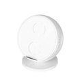 Black ABS plastic wireless phone charger holder with integrated Bluetooth speaker on a wooden desk.