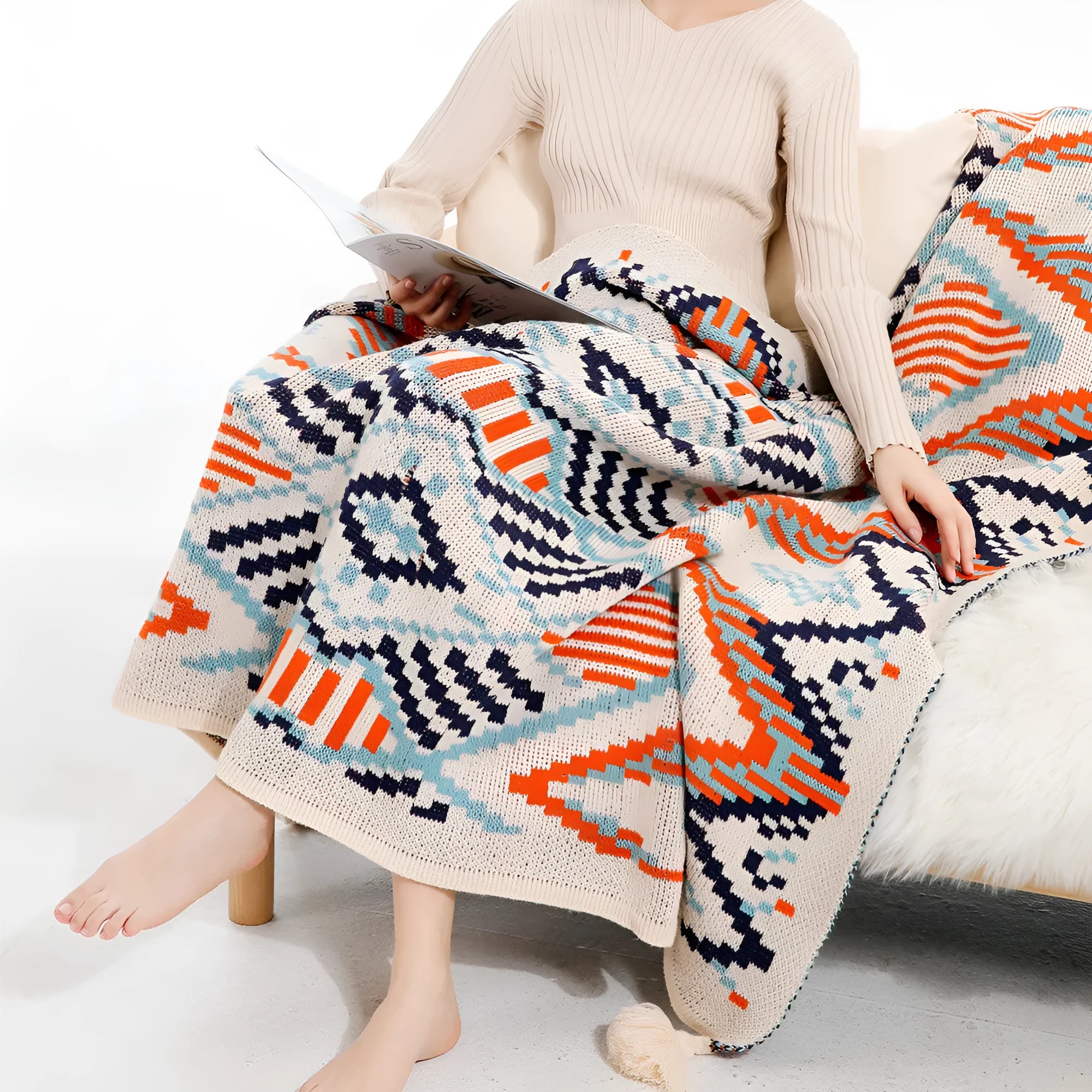 Bohemian style acrylic blanket with tassel fringe on a sofa, shown in a geometric print colour.