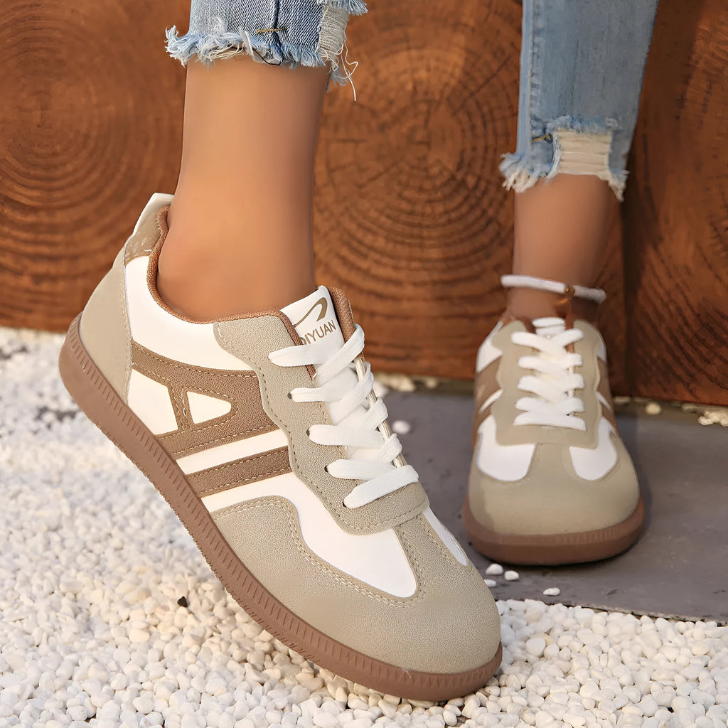 Women's retro style lace-up jogging shoes in grey with a cross strap and low platform heel.