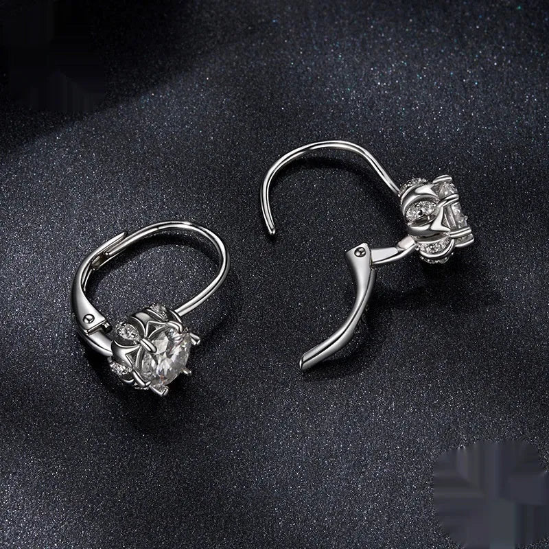 Close-up of a sterling silver flower bud ear clip with a white gold plated finish and a central moissanite stone.