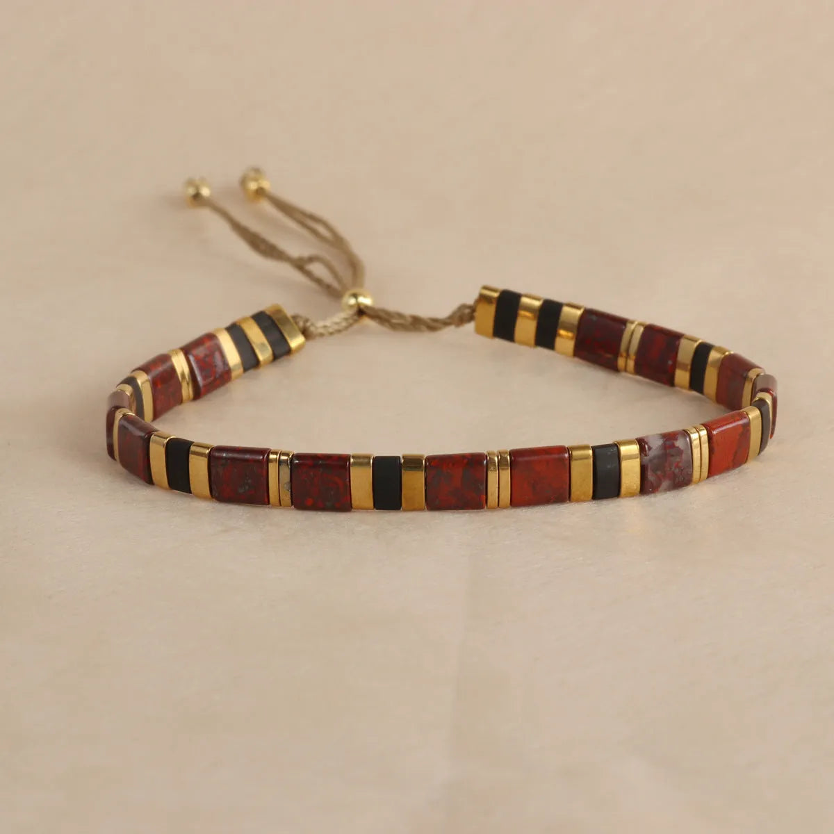 Geometric glass and coloured glaze beaded bracelet in milky white on a wrist.