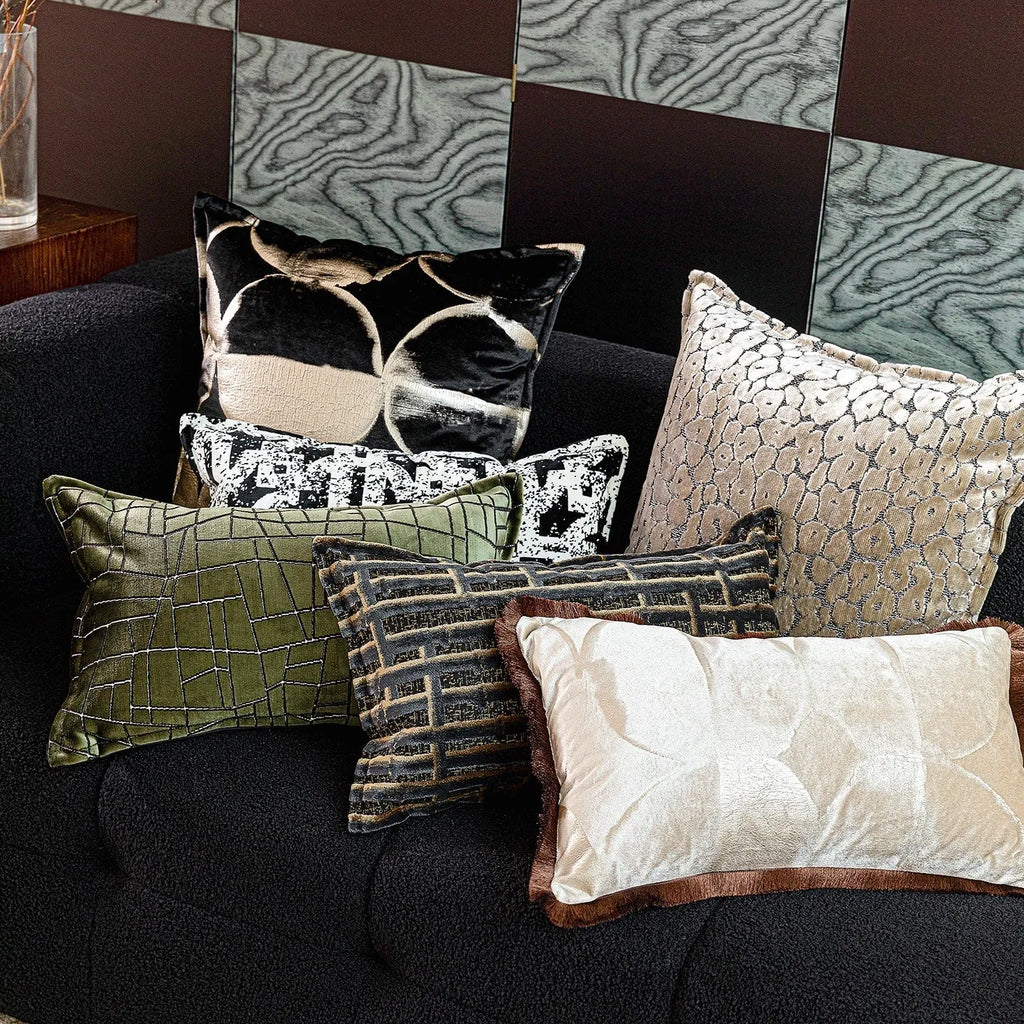 Black and gold abstract patterned square cushion on a grey sofa
