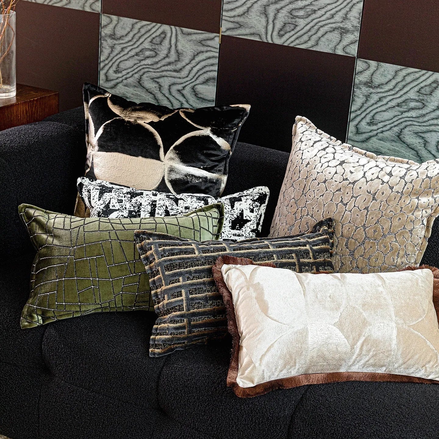 Black and gold abstract patterned square cushion on a grey sofa